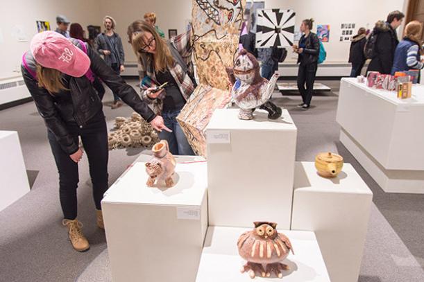 Patrons view artwork in an exhibit in the H. F. Johnson Gallery of Arts.